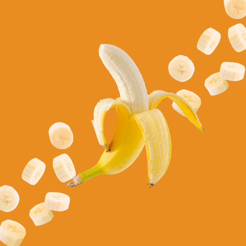 Banana and banana slices on a burnt orange background representing Wild Desert Dye-FREE Banana Coffee Syrup. Made with non-GMO 100% pure cane sugar and crafted in small batches by a family-owned business in Tucson, Arizona. Sweet, creamy banana flavor adds tropical taste to coffee, lattes, teas, smoothies, and specialty drinks.