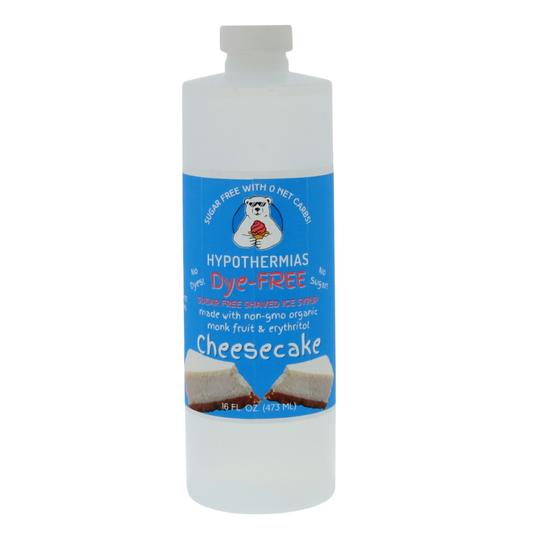 A pint of Hypothermias Sugar-Free & Dye-Free Cheesecake Shaved Ice and Snow Cone Syrup in a BPA-free plastic bottle on a bright white background, featuring an azure blue label with a cheesecake illustration. This clear, sugar-free shaved ice syrup is made with organic and non-GMO monk fruit and erythritol for a creamy, naturally sweet flavor without dyes or added sugars.