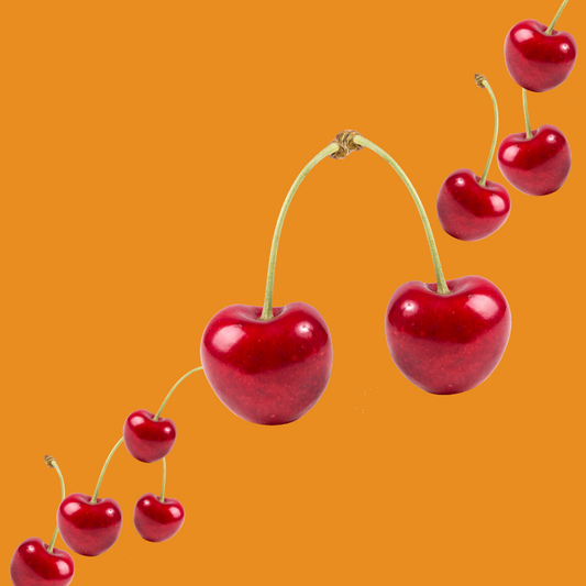 Fresh cherries on a burnt orange background representing Wild Desert Dye-FREE Cherry Coffee Syrup. Made with non-GMO 100% pure cane sugar and crafted in small batches by a family-owned business in Tucson, Arizona. Clear pour, dye-free syrup with a sweet cherry flavor, no high-fructose corn syrup, perfect for coffee, lattes, teas, smoothies, and specialty drinks.