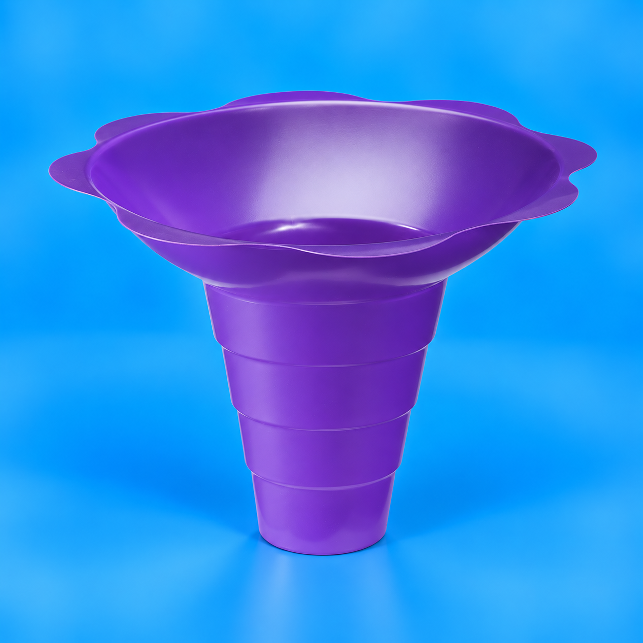 A purple plastic large shaved ice flower cup with a flared, scalloped rim and a tapered body, shown on a bright blue background.