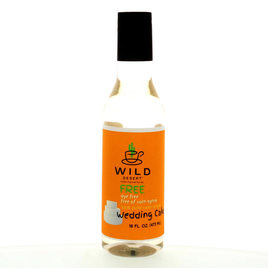 Picture of a 12 fluid ounce bottle of Wild Desert Dye-FREE syrup for coffee with an orange label. The flavor is Wedding Cake. Made with non-GMO 100% pure cane sugar and no corn syrup.